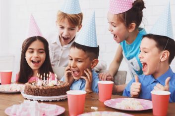 kids-birthday-party-boy-blowing-out-candles-on-cake-1024x576